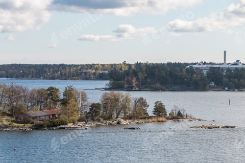 Preview: view from the ship to the rocky coast of Sweden. typical swedish houses on the rocks. cloudy sky