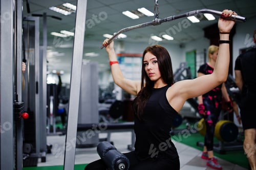 Preview: Young sport girl workout in gym. Fitness woman doing exercises.