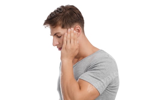 Preview: Unhappy young caucasian handsome guy presses his hand to temple and suffers from headache