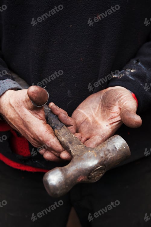 Preview: Close up of a blacksmith's hands, holding a metal hammer.