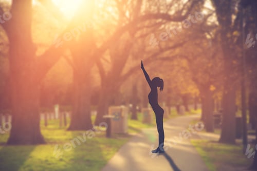 Preview: Silhouette Young Woman Practicing Yoga On Public Park At Sunset.Vintage Color