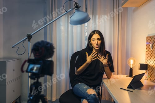 Preview: Selective focus shot of a young beautiful lady doing a video blog shooting in her room