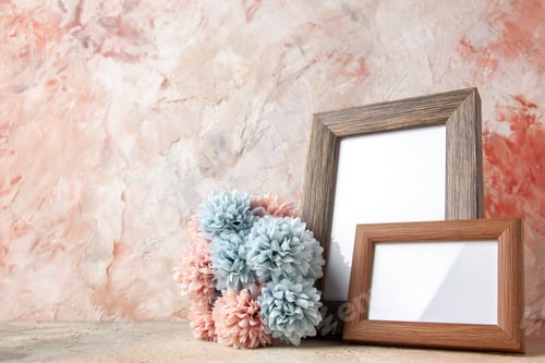 Preview: Top view of brown small and big empty wooden photo frames standing on table and flower on the left