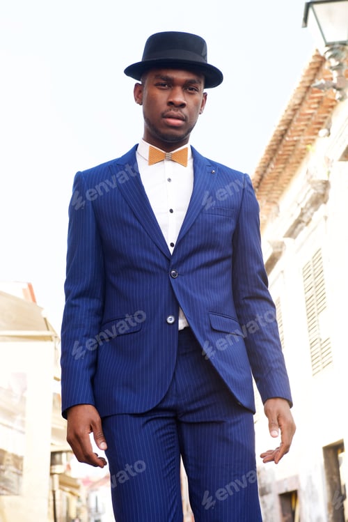Preview: cool african american male model standing on city street with suit and bowtie