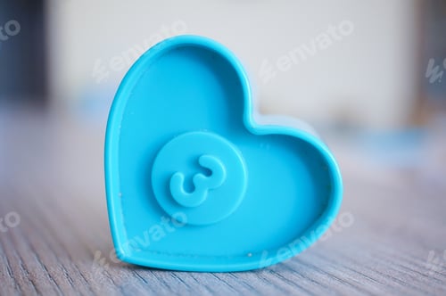 Preview: Closeup shot of a blue plastic heart-shaped toy with number three on a center