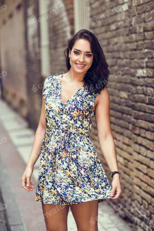 Preview: Girl with blue eyes smiling on brick wall.
