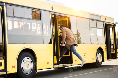 Preview: full length view of young man holding digital tablet and entering bus
