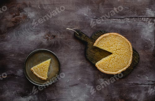 Preview: top view of tasty lemon pie on wooden board and plate