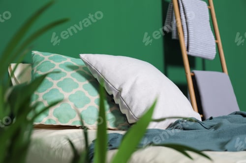 Preview: Soft pillows and plaid on comfortable bed indoors. Idea for interior design