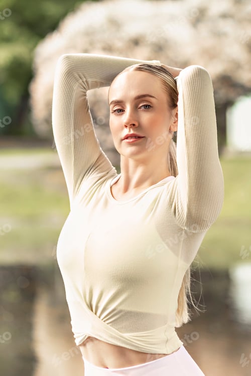 Preview: A young beautiful slender girl with long blonde hair does yoga in the summer in the park