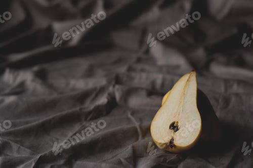 Preview: Minimal shot of cut pear on linen tablecloth