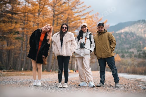 Preview: Four people are posing for a photo in the woods
