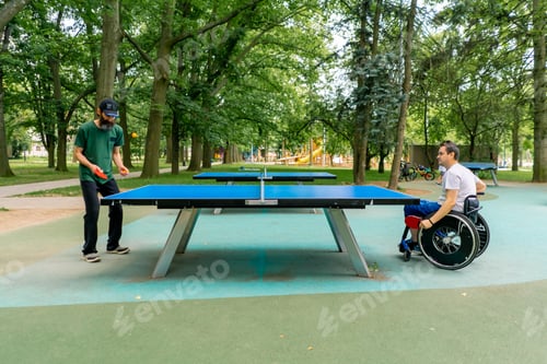 Preview: A disabled man in a wheelchair plays ping pong against an old man with a gray beard in city park