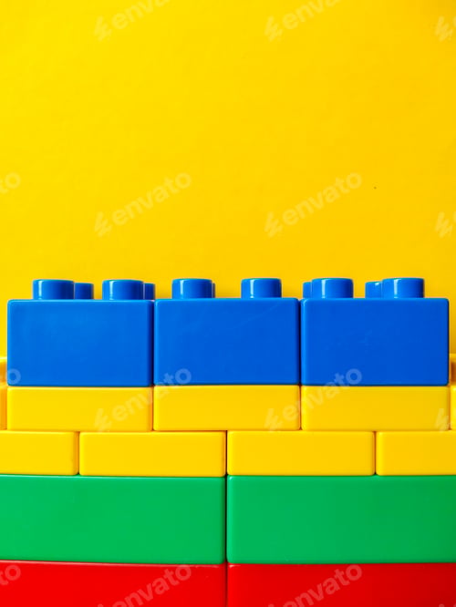 Preview: Close up of kids colorful toy constructor details on yellow background