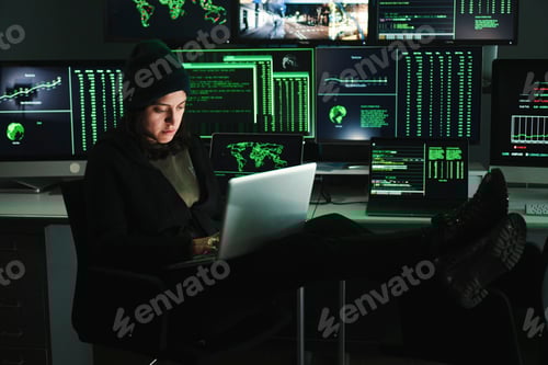 Preview: Informatic hacker woman typing code on laptop, at background a lot of computer screens with data