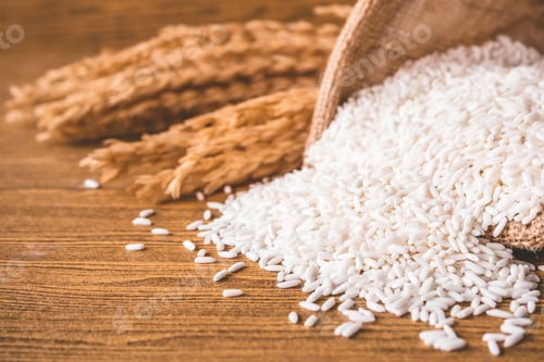 Preview: Close up of raw rice in burlap sack on wooden table.
