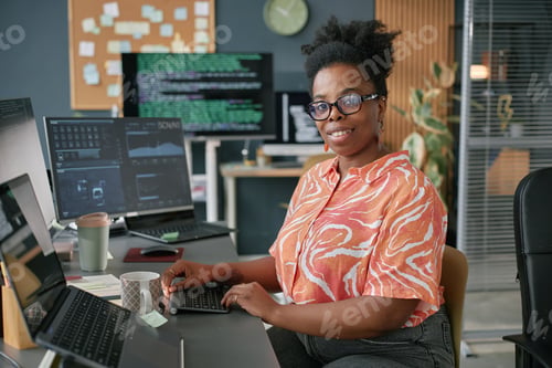 Preview: Portrait of Young Adult Black Woman Working at Computer in Modern Office