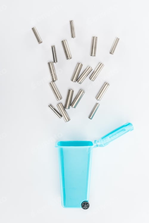 Preview: Top view of blue toy trashcan and batteries on grey background