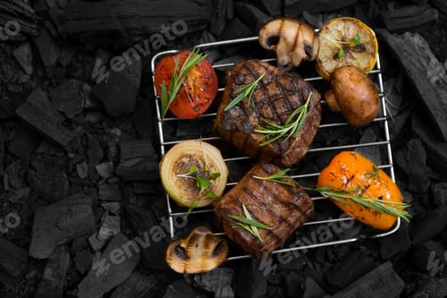 Preview: Flat lay of well done meat steak with vegetables on coals