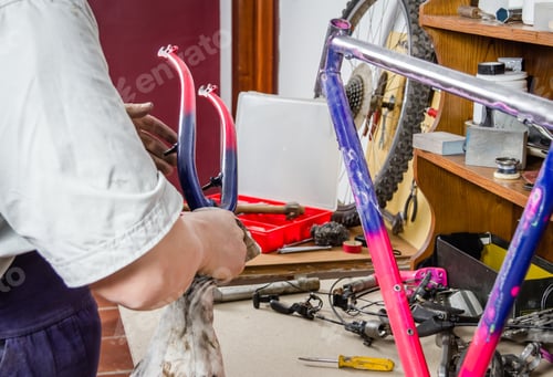 Preview: Hands of real bicycle mechanic cleaning frame bike