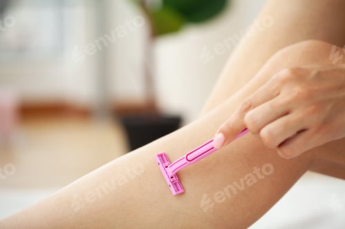 Preview: Close up of woman shaving legs in bathroom