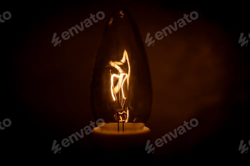 Preview: Light bulb glows brightly against a dark background, emitting a warm light