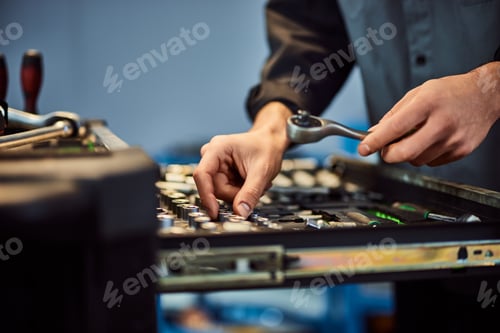 Preview: Focus on the mechanic's hands opening a drawer and choosing the right tool.