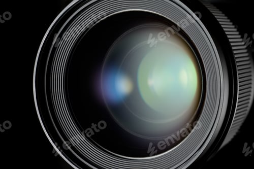 Preview: Close-up of a camera lens with bright light reflected in the glass.