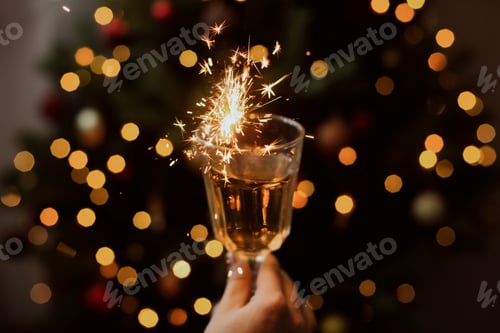 Preview: Burning firework in champagne glass in hand