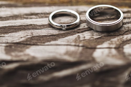 Preview: Couple of wedding rings with diamond close up on shabby wooden texture