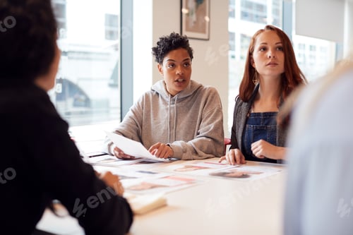 Preview: Team Of Young Businesswomen In Meeting Around Table In Modern Workspace