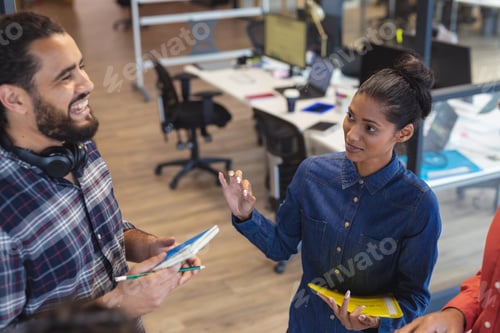 Preview: Diverse group of creative colleagues talking at casual meeting