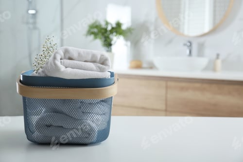 Preview: Basket with clean soft towels in bathroom. Space for text