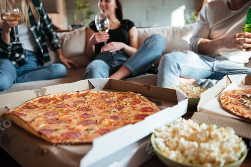 Preview: Happy people eating pizza, drinking wine and beer on sofa
