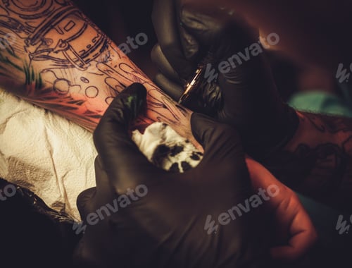 Preview: Tattoo artist makes a tattoo on a man's hand.