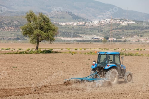 Preview: Tractor ploughing on the field in sunlight