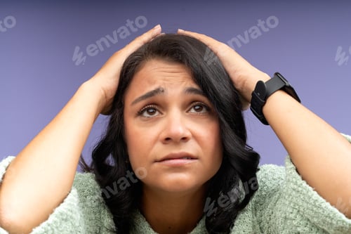 Preview: Stressed young woman holding head in hands, frustration and despair
