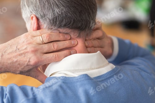 Preview: Elderly Man Having Neck Pain Sitting On Sofa, Rear View
