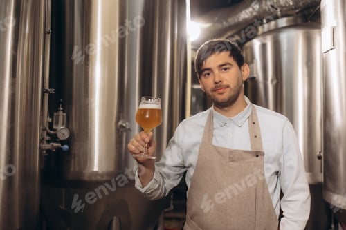 Vista previa: Joven cervecero con un vaso de cerveza en la mano Comiendo cerveza artesanal para comprobar el sabor