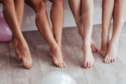 Preview: Cropped close up photo of legs of four women sitting in the bedroom