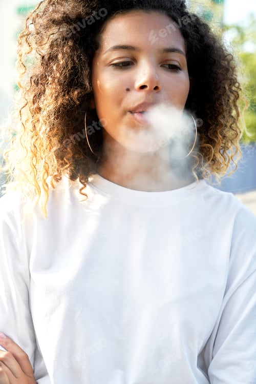Preview: Young woman standing and smoking cigarette