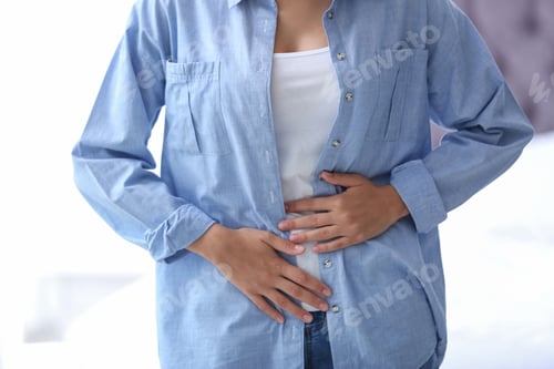 Preview: Young woman suffering from menstrual cramps on light background. Gynecological care