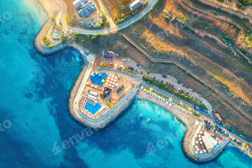 Preview: Aerial view of sandy beach, blue sea, restaurants at sunset