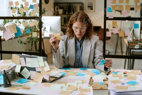 Preview: Caucasian Woman Organizing Sticky Notes While Working in Office