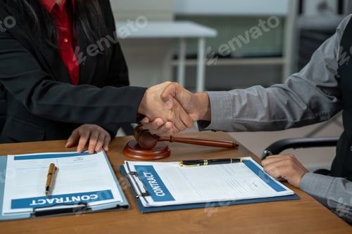 Preview: Middle age partner lawyers attorneys shaking hands after discussing a contract agreement done.