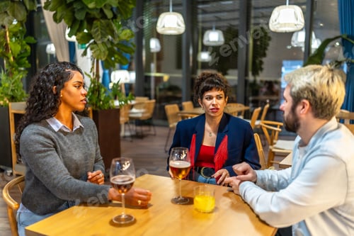 Preview: Coworkers enjoying beer together after work outside a bar