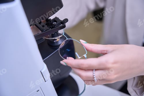 Preview: Woman specialist works with lenses on a modern device