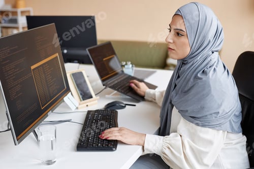 Preview: Muslim Woman Wearing Modest Clothing in Office as Female IT Developer Coding