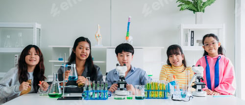 Preview: Group of Primary class children engaged in hands-on scientific experiments.