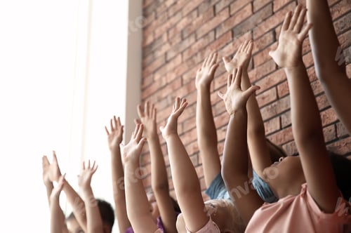 Preview: Little children raising hands together indoors. Unity concept